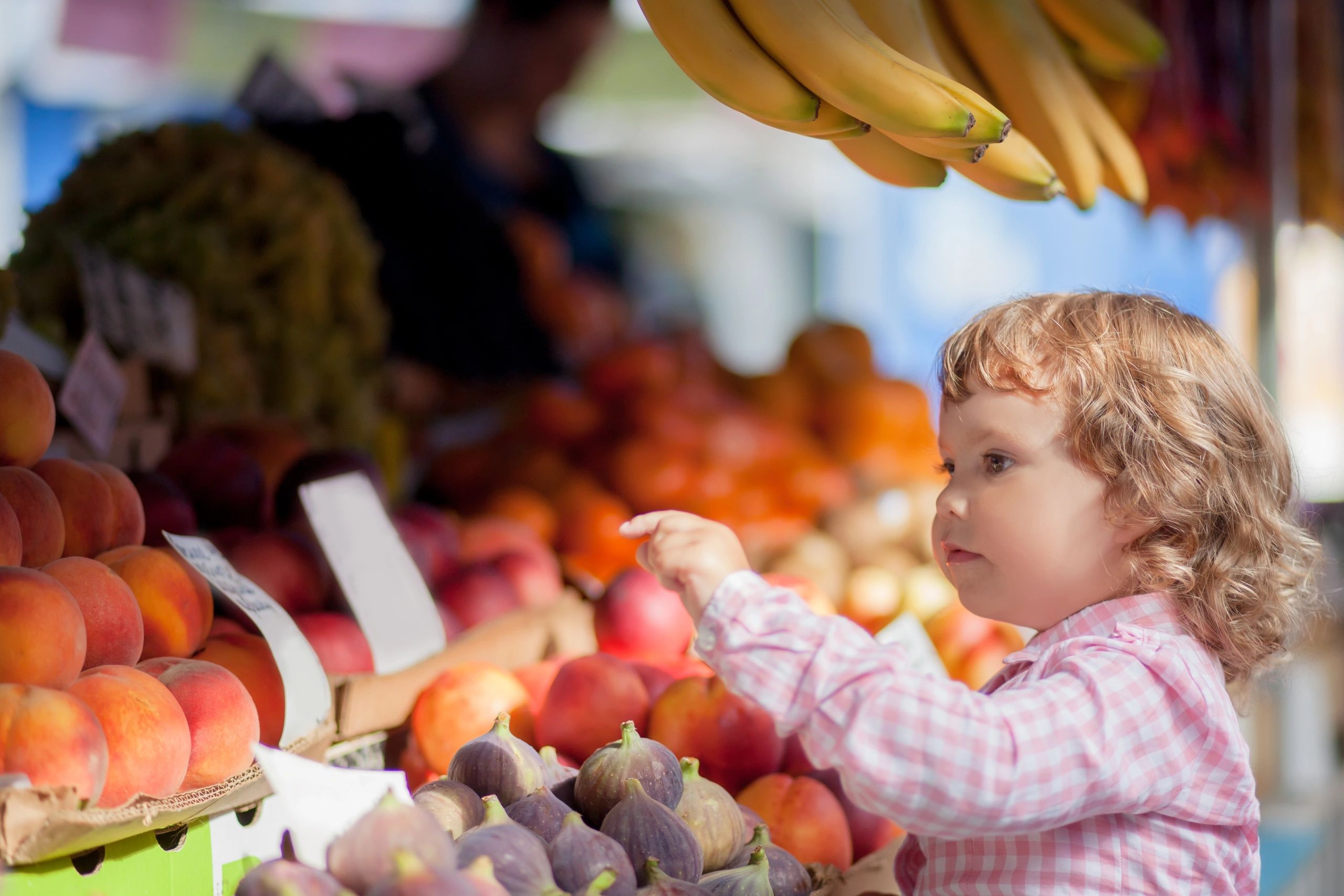 Toddler girl choosing items at the market